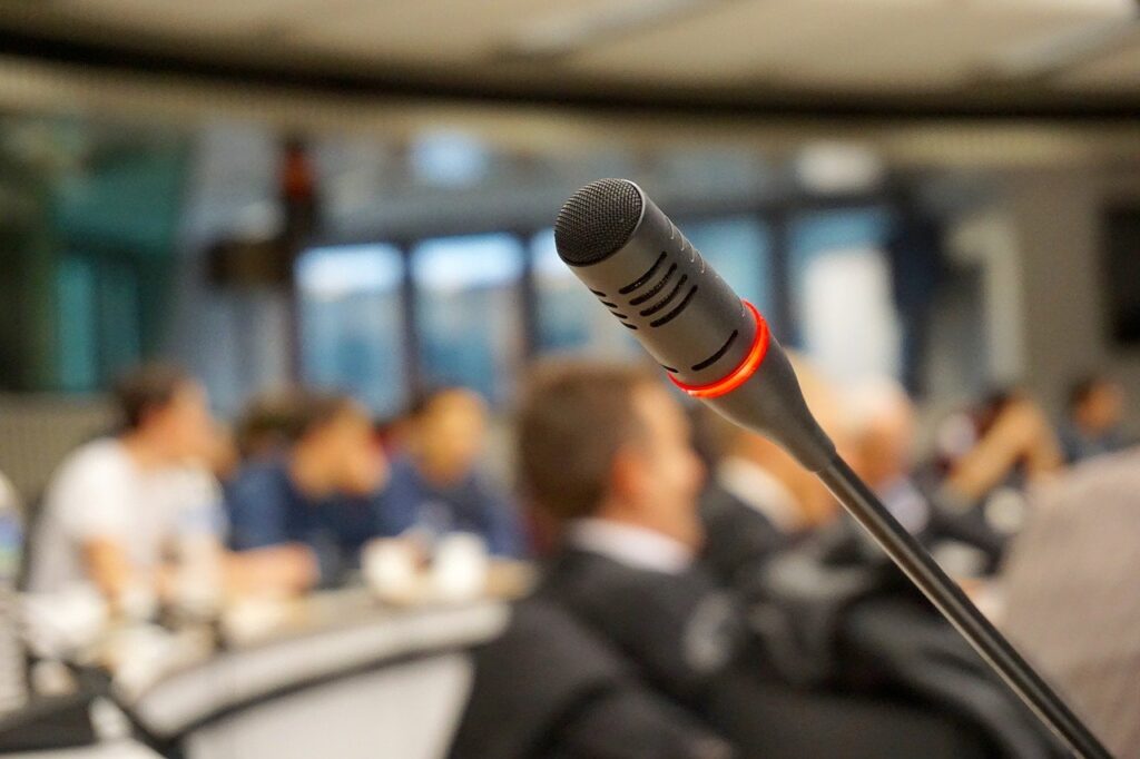 Microphone and blurred image of a meeting in the background