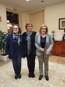 Three women smile at the camera