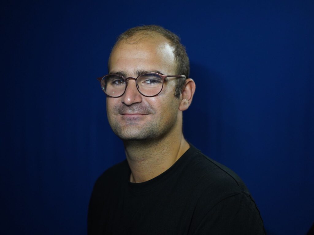 Headshot of Pere, a caucasian man who wears glasses